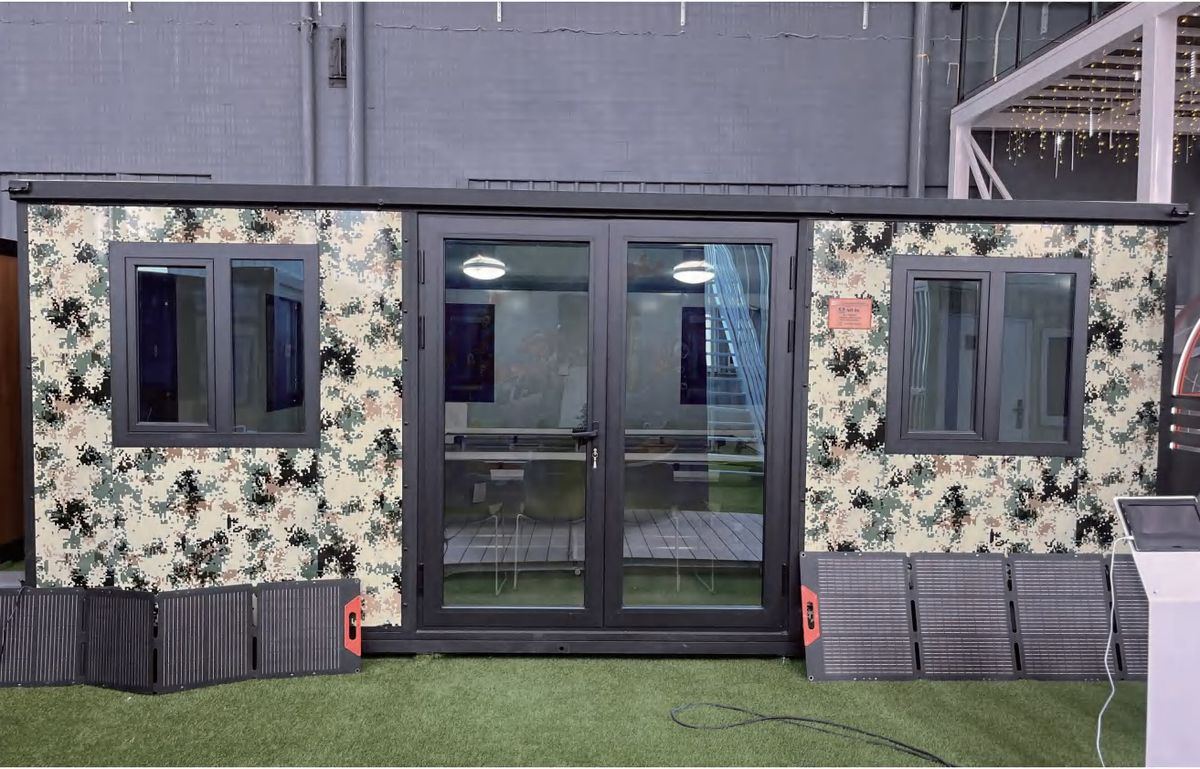 Expandable house with solar panels in camouflage finish